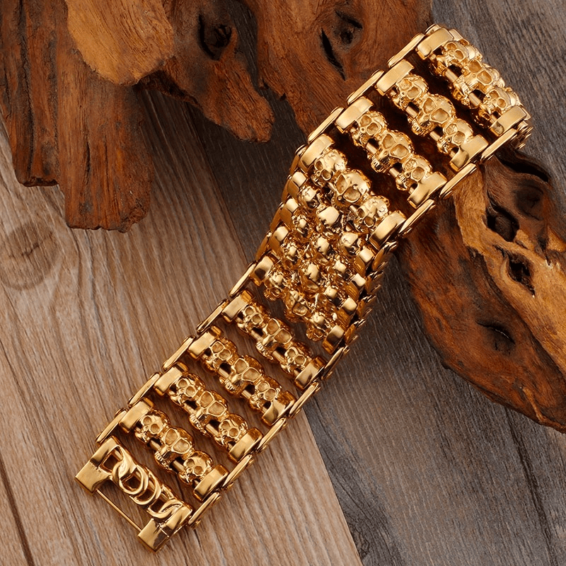 Stylish punk skull bracelet for men in gold stainless steel, showcasing multiple skull charms on a wide band.