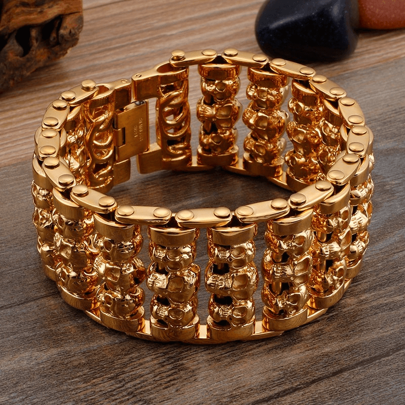 Punk style men's charm bracelet with multiple skull heads in gold, made of 316 stainless steel, trendy accessory for fashion lovers.