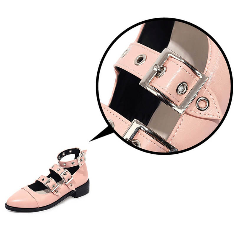 Close-up of women's punk style PU leather pumps with buckle straps in soft pink, showcasing edgy design and detail.