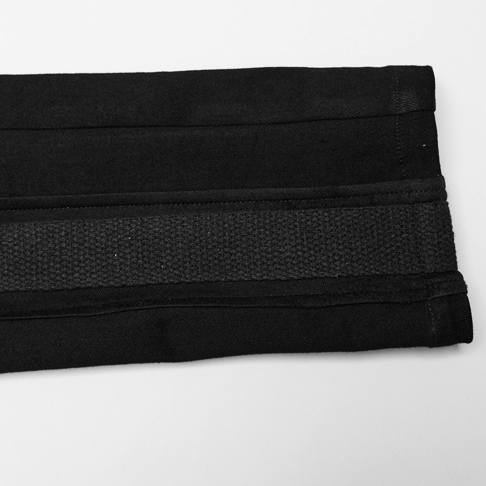 Close-up of black elastic denim with textured splices, showcasing punk-inspired design elements.