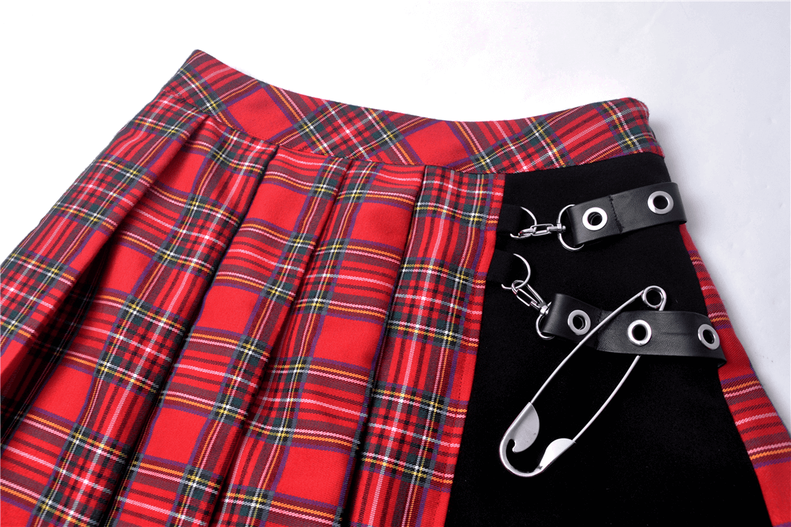 Edgy red and black plaid mini skirt with pleats and safety pin details for a punk rock look.