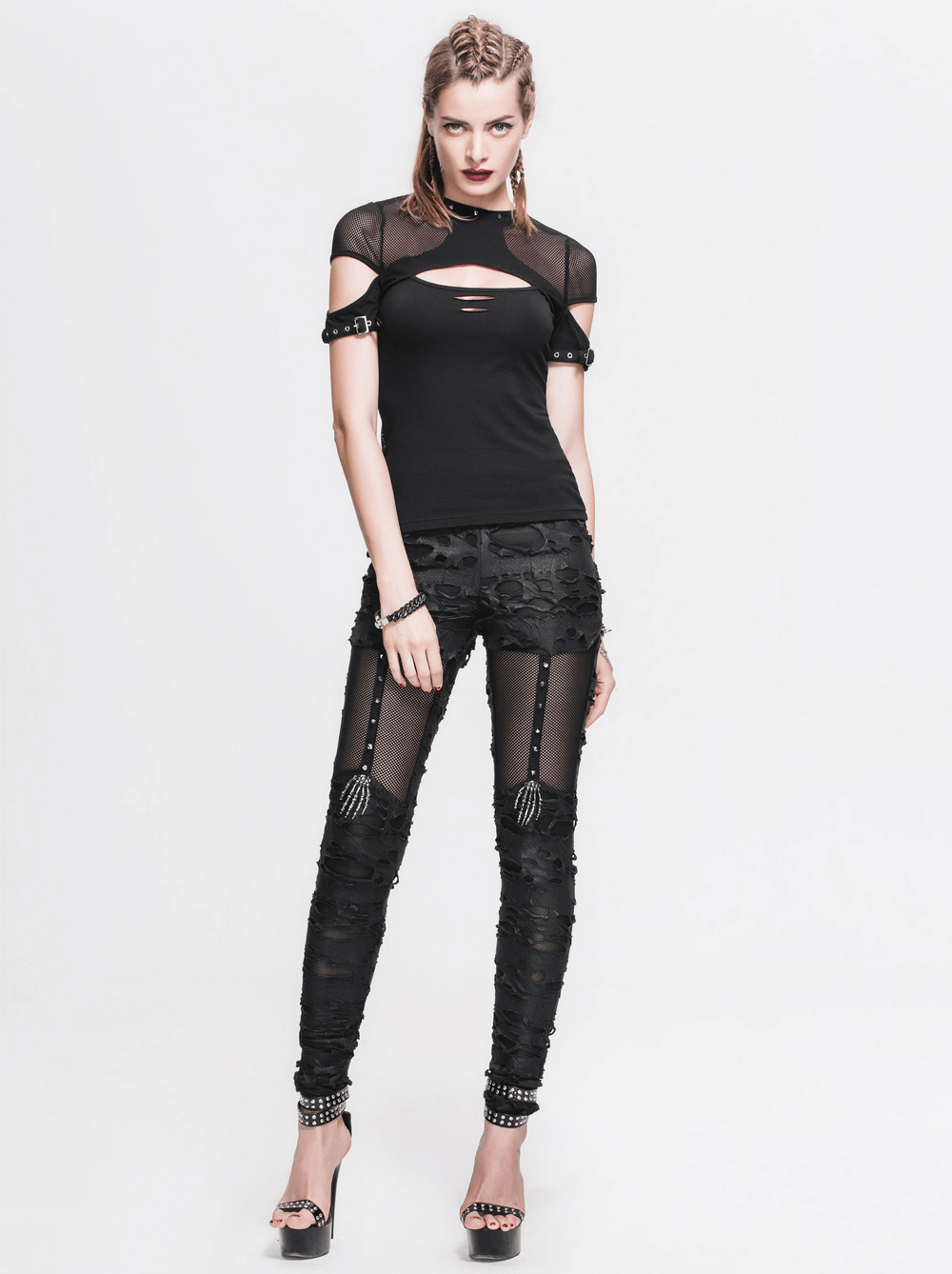 Gothic-inspired women's punk tattered leggings styled with a black mesh top and edgy accessories.