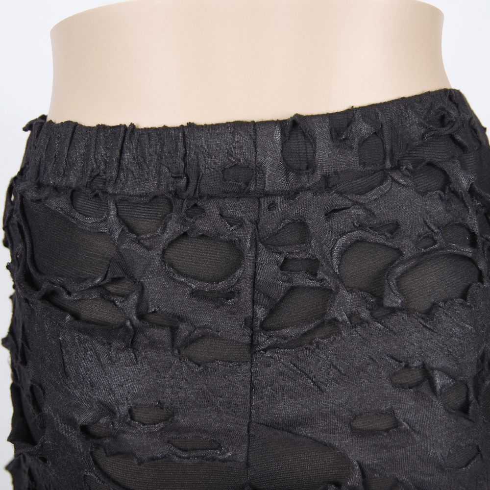 Close-up of black punk tattered leggings showcasing ripped design and high waistband for gothic fashion.