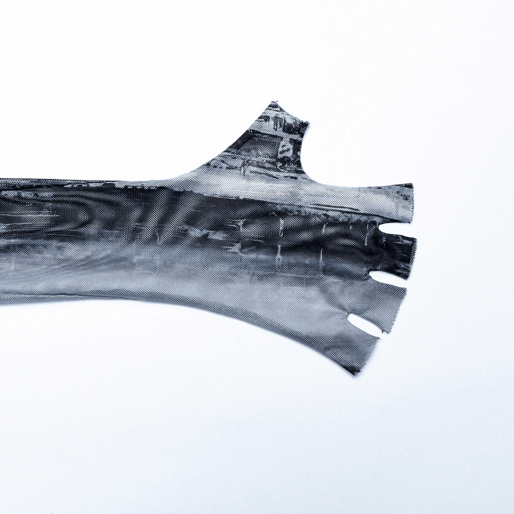 Close-up of distressed elastic mesh fabric with finger holes for a punk techwear long sleeve top.