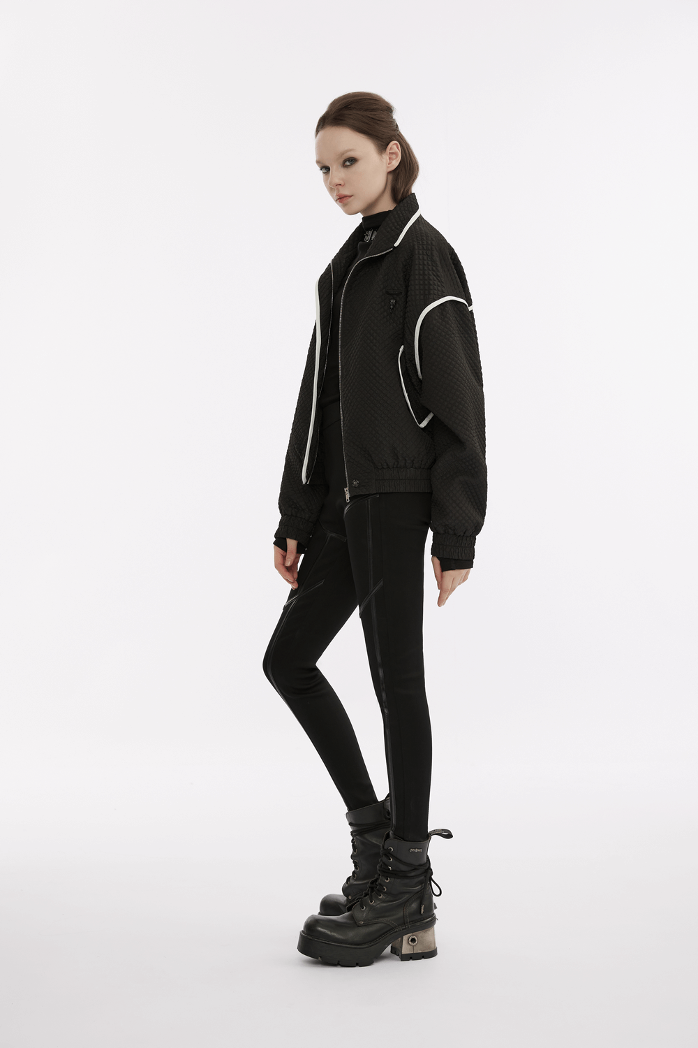 Punk techwear style model in black bomber jacket with faux leather leggings and chunky boots, showcasing edgy fashion.