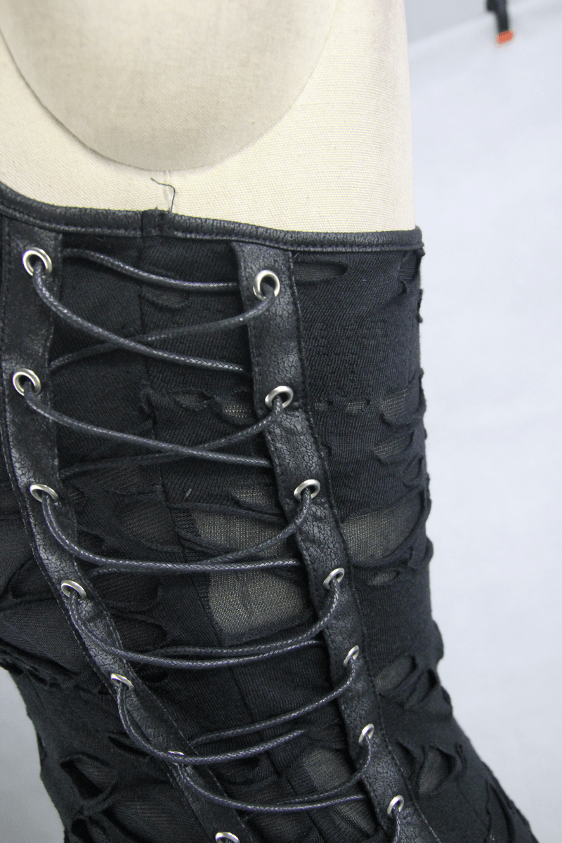 Close-up of gothic black tank top showing lace-up detail and torn design, perfect for punk fashion enthusiasts.