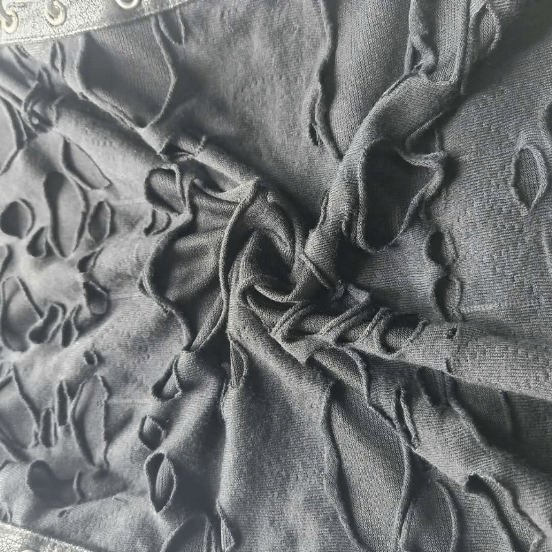 Close-up of a black punk tank top with irregular holes and lace-up detail, showcasing its edgy design.