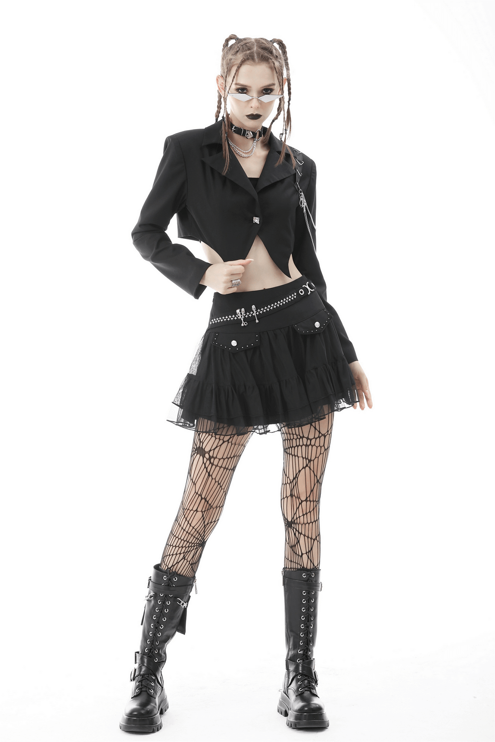 Punk women's cropped jacket with chain details, styled with a black skirt and fishnet tights for a bold goth look.