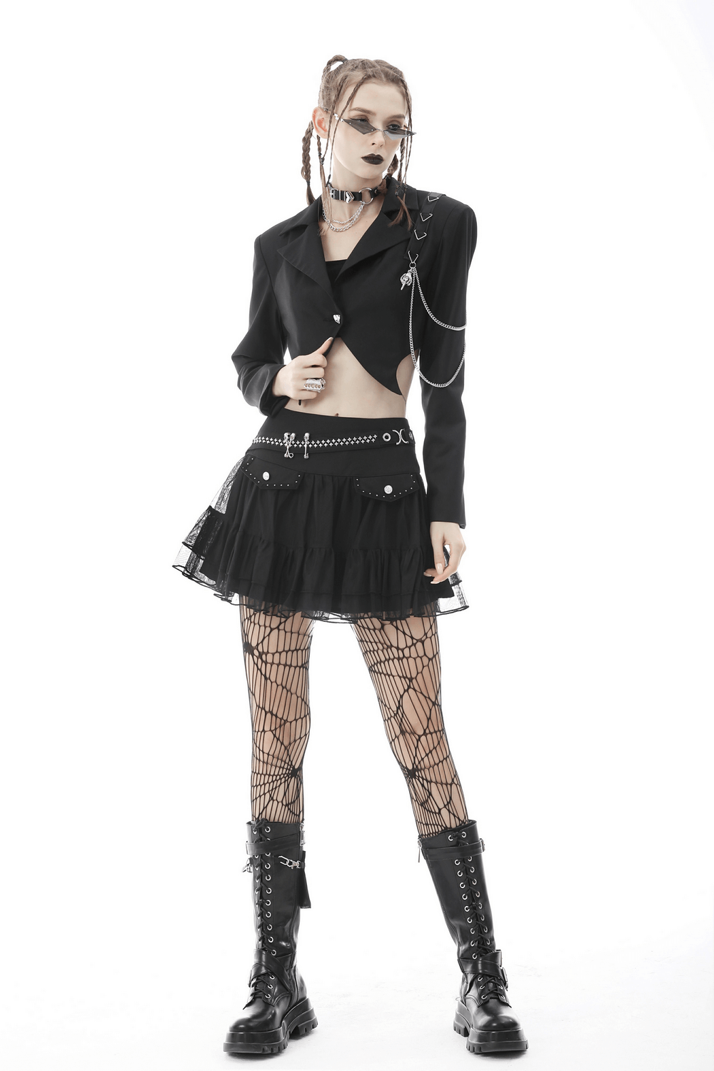 Punk women's cropped jacket with chain details, paired with black mini skirt and fishnet tights for a bold goth look.