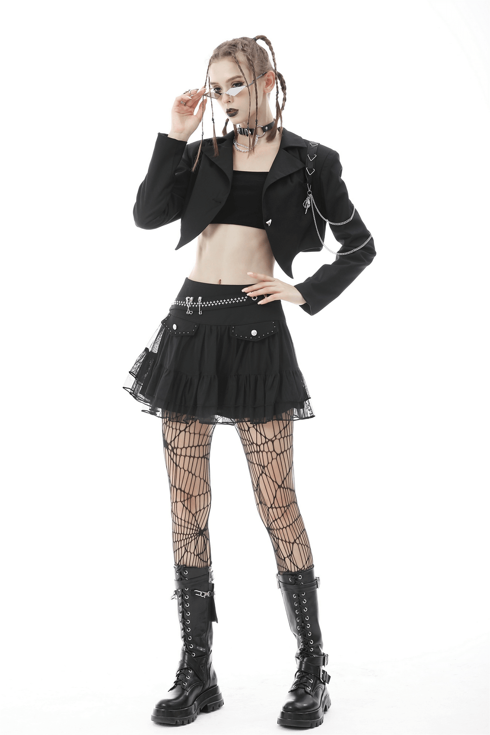 Punk women's crop jacket with chains, paired with a black skirt and fishnet tights for an edgy goth look.