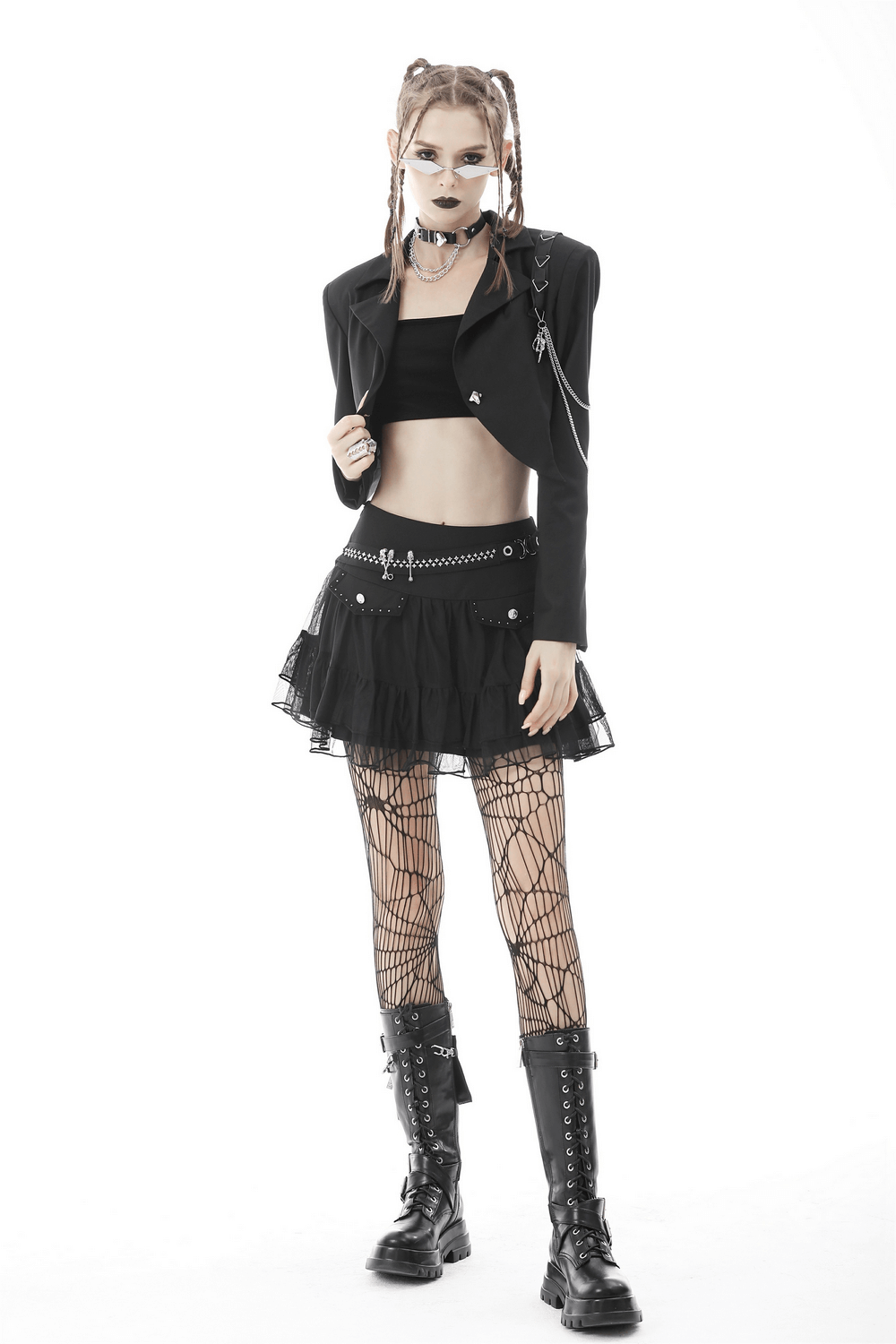 Punk women's crop jacket with chain details, paired with a black skirt and fishnet tights for a bold goth look.