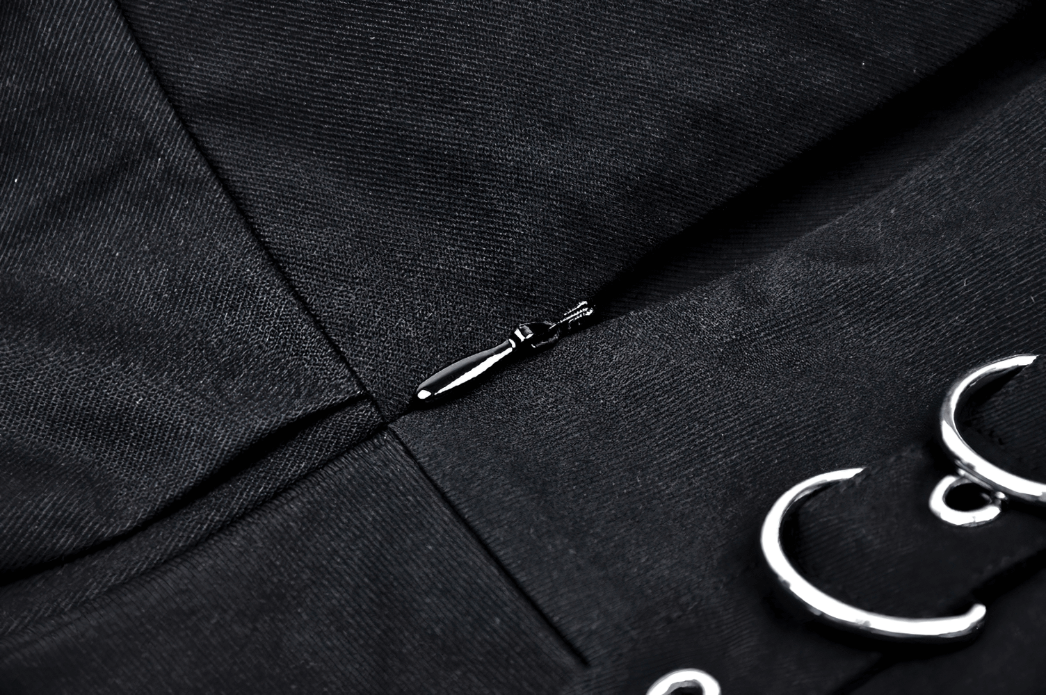 Close-up of a black punk mini skirt showing lace trim and silver o-rings, perfect for adding edge to any outfit.