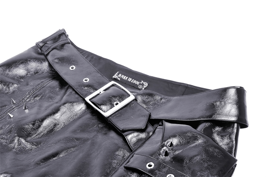 Close-up of black vegan leather mini skirt with spiked accents and a bold belt for punk style.