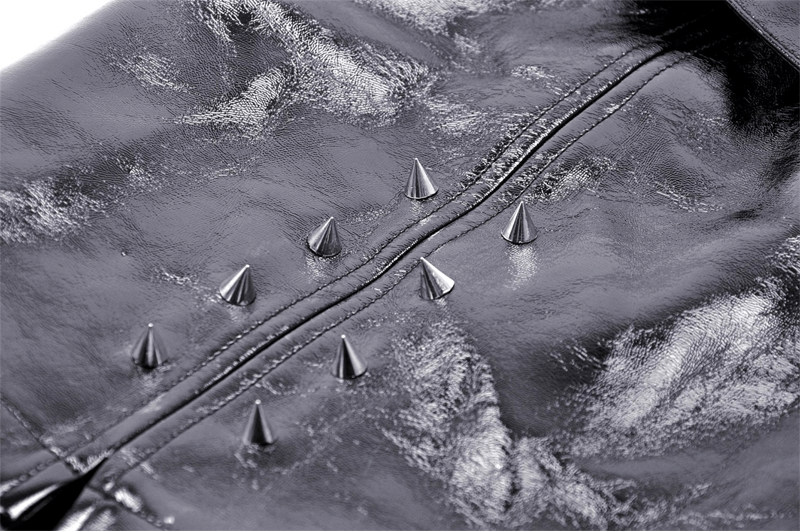 Close-up of punk mini skirt showing spiked accents on sleek vegan leather for bold gothic style.