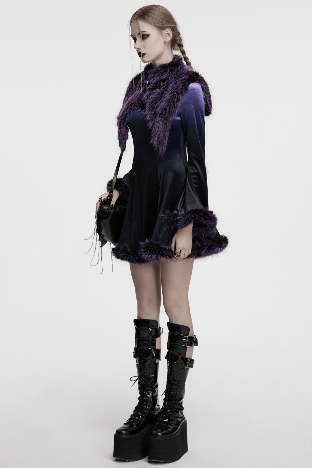 Model wearing a purple faux fur capelet dress with wide sleeves and chunky boots, exuding a gothic vibe.