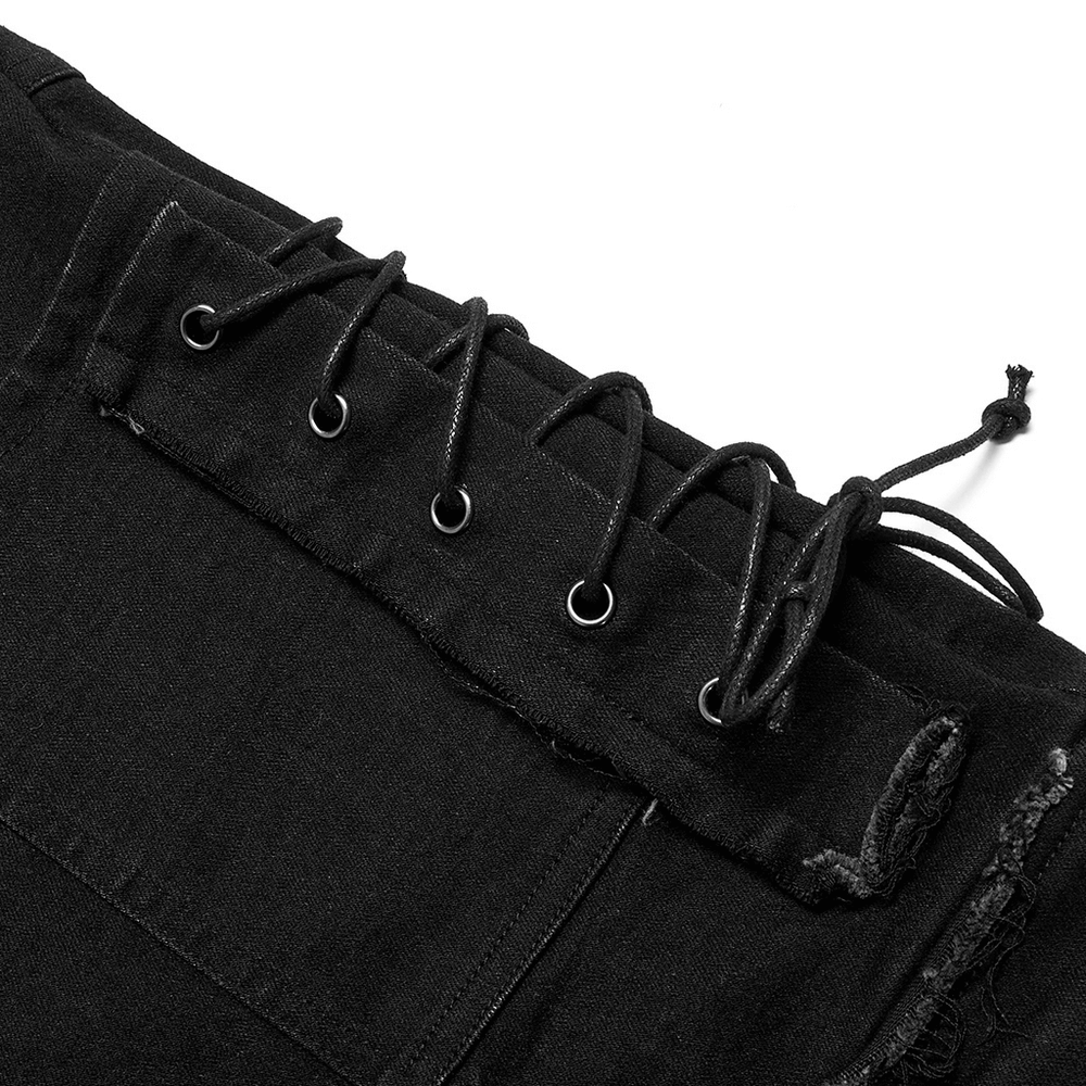 Close-up of ragged mesh splice punk denim trousers showcasing drawstring and metal accent details.