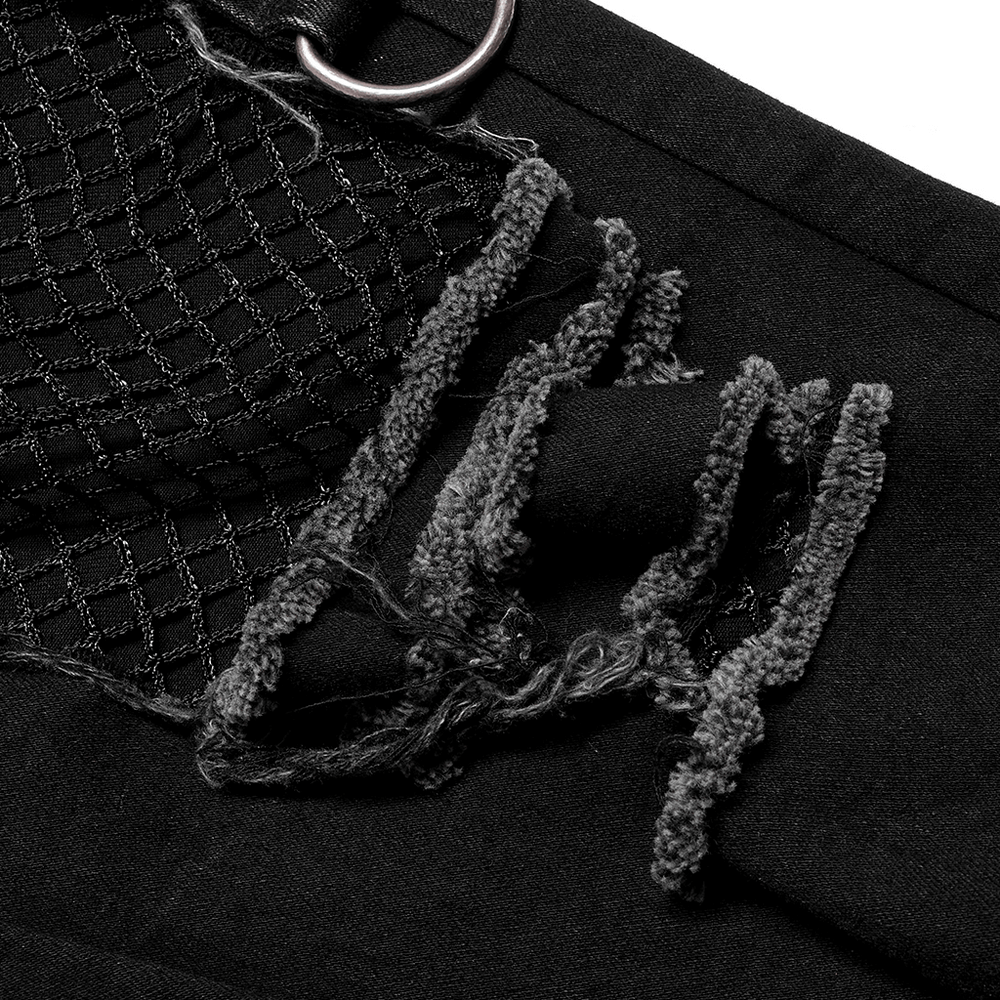Close-up of ragged mesh detail on punk decadent denim trousers, showcasing edgy design and rebellious style.