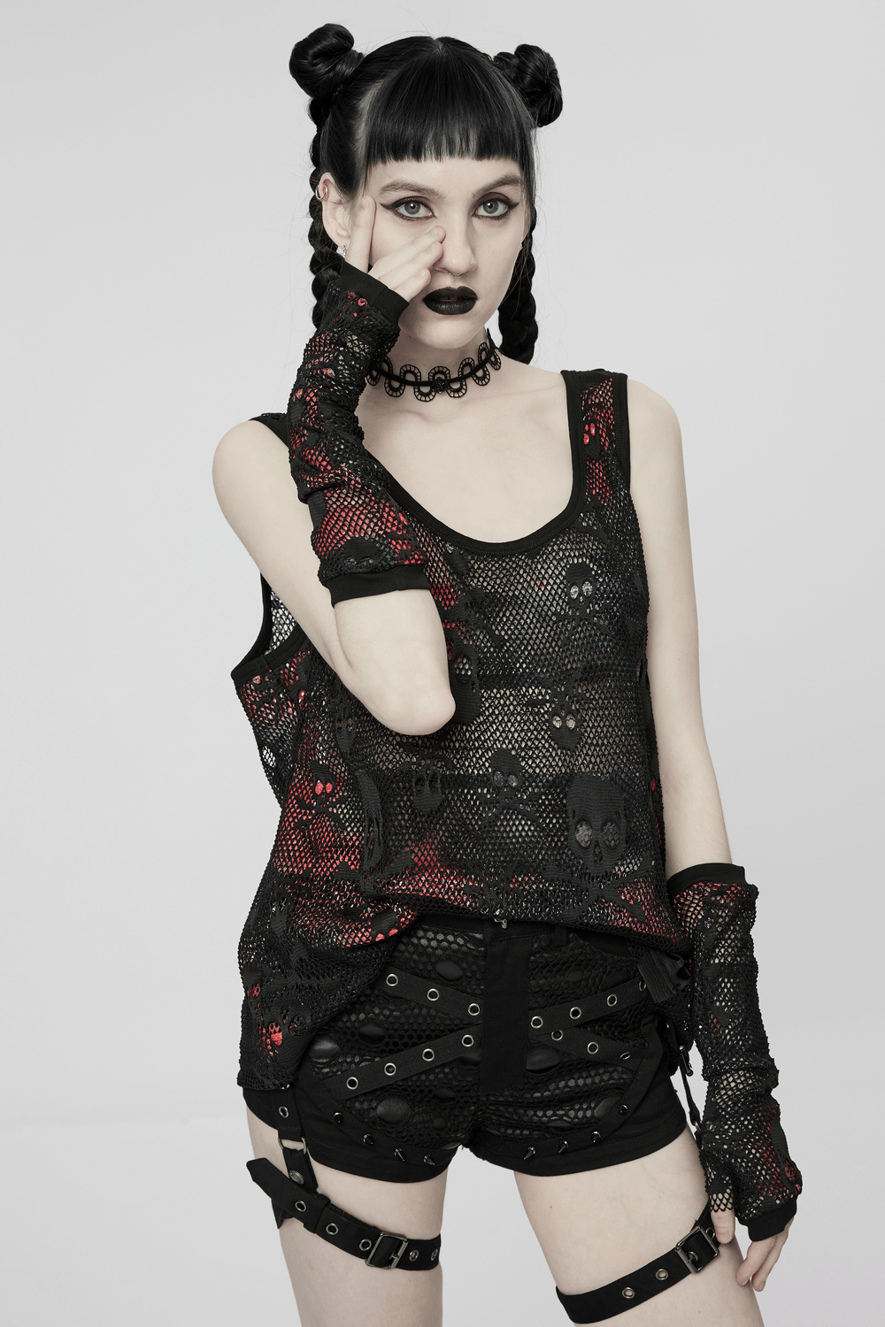 Model in black skull mesh overlay tank and fingerless gloves, showcasing punk style with bold statement fashion.