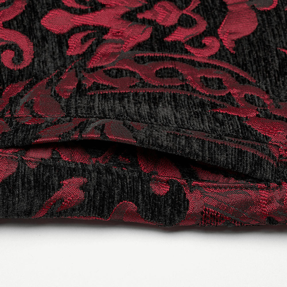 Close-up of red and black gothic jacquard fabric showcasing intricate Victorian patterns.