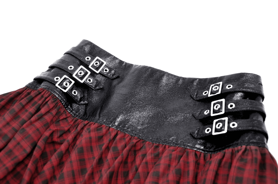 Close-up of the waistline of a red and black tartan gothic mini skirt with stylish black faux leather belt details.