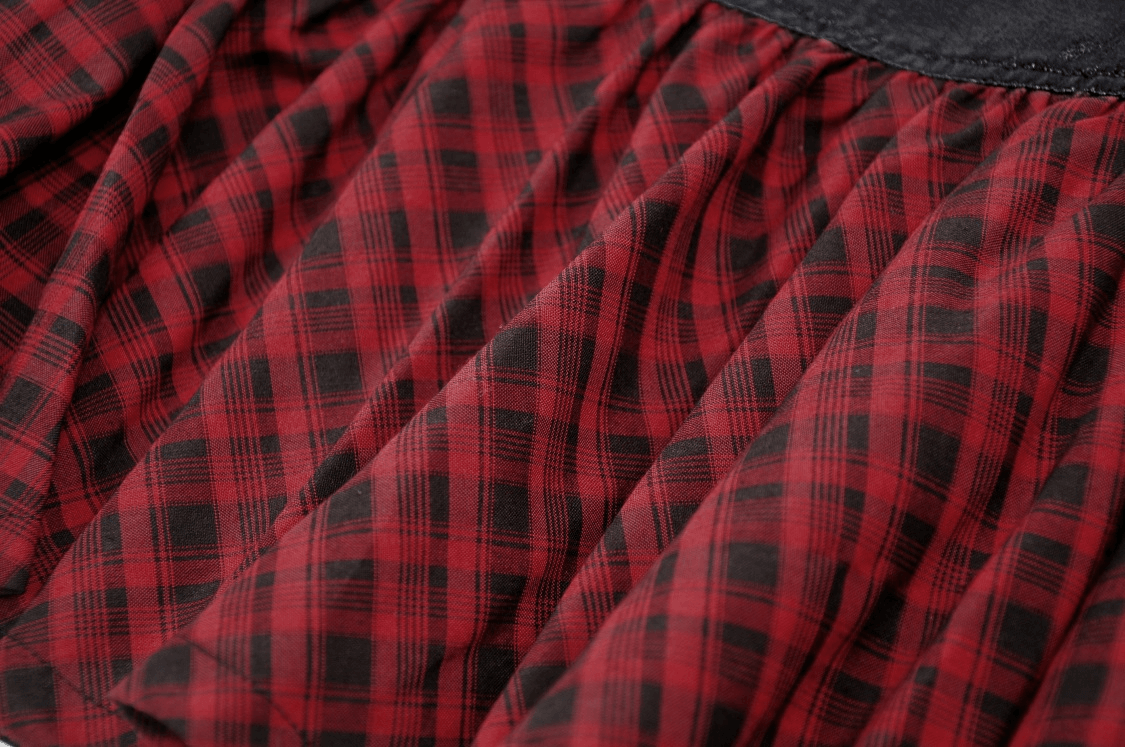 Close-up of red and black tartan fabric with pleats from a gothic mini skirt.