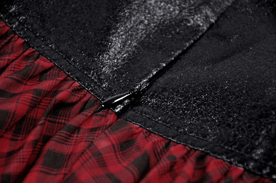 Close-up of the zipper detail on a red and black tartan gothic mini skirt with faux leather accents.