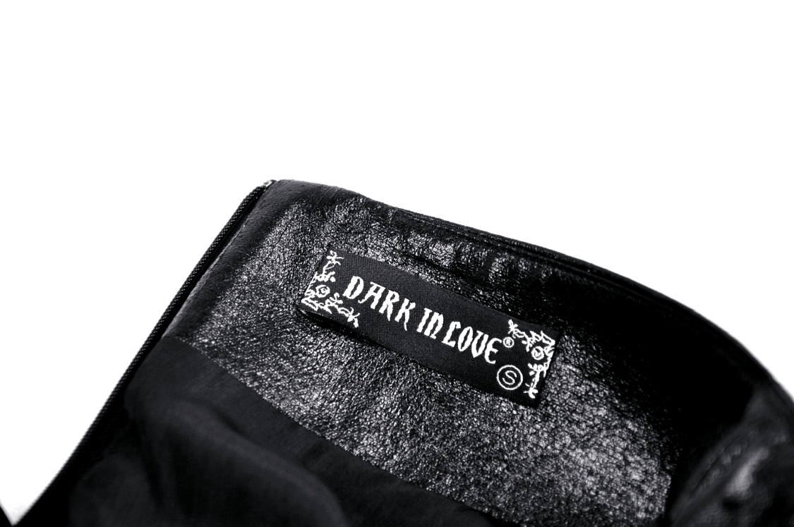 Inside label of a Dark in Love gothic mini skirt, showcasing dark branding on black fabric.