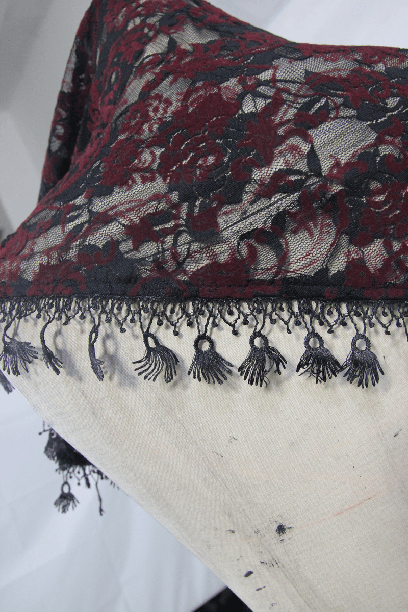Black and red lace fabric with intricate floral design and decorative fringe, perfect for gothic nightwear.