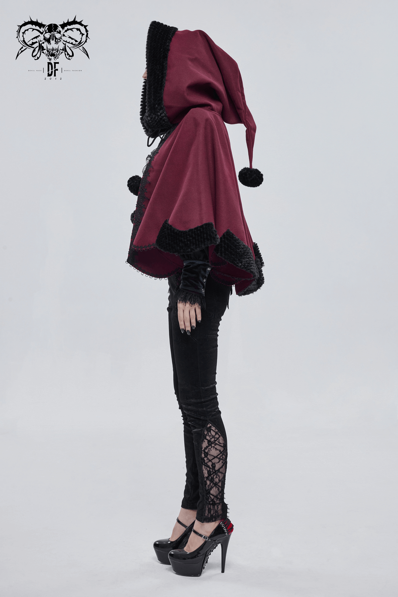 Side view of a woman wearing a red gothic hooded cloak with black fur trim and pompons, paired with stylish black pants.