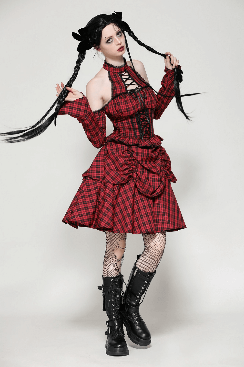 Stunning woman in a red plaid gothic corset dress with ruffles and lace-up details, exuding Victorian charm.