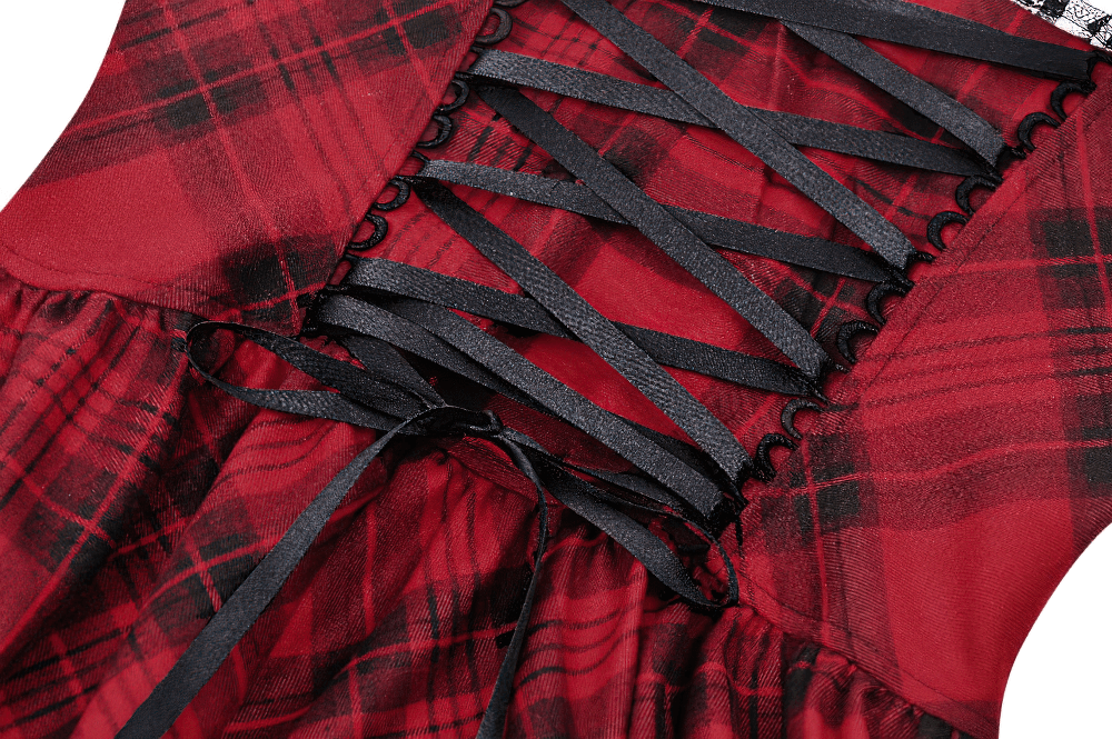 Close-up of red plaid gothic mini dress showcasing lace-up back and black ribbon details for a punk-inspired look.