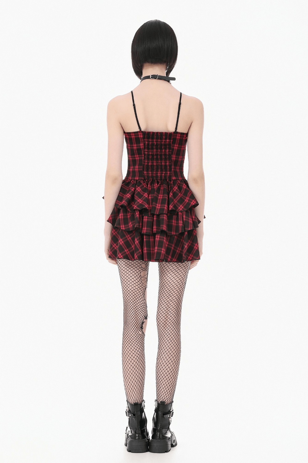Back view of a model wearing a Red Plaid Punk Mini Dress with Tiered Ruffles, paired with fishnets and chunky boots.