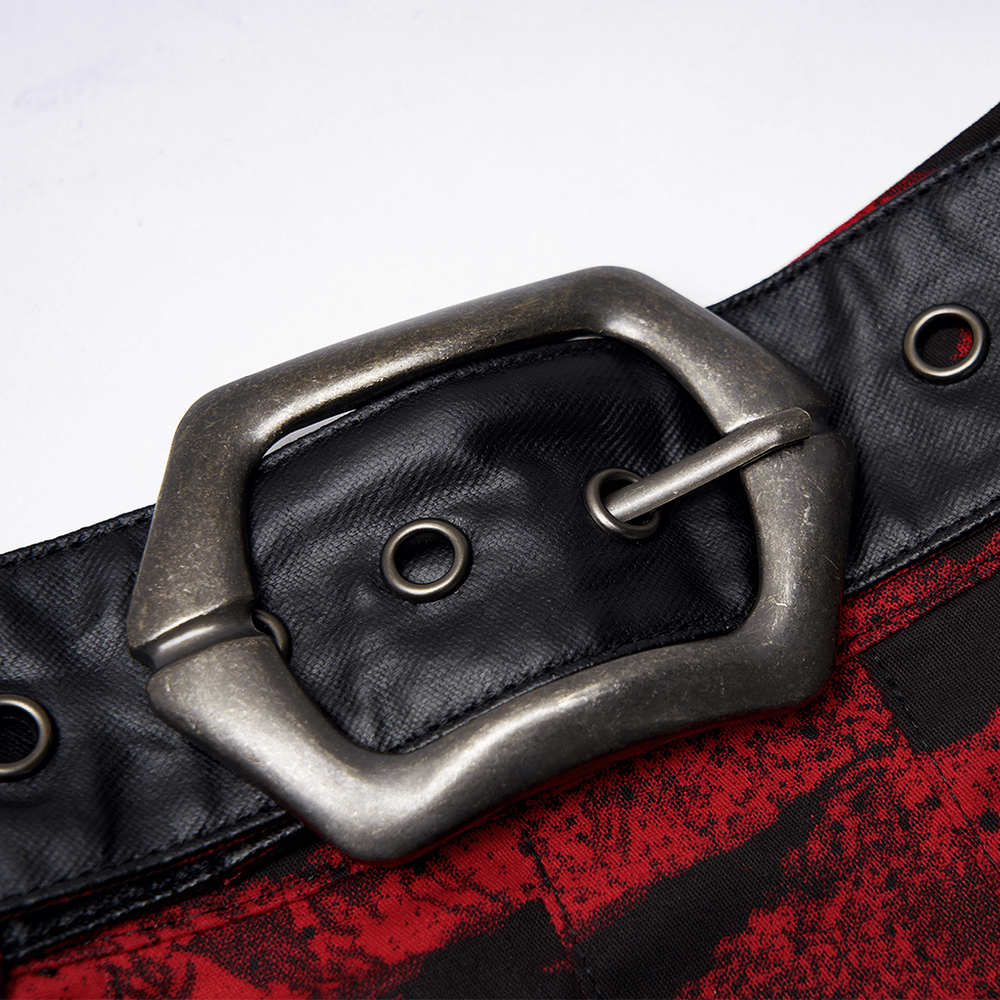 Close-up of a heavy metal buckle on a red abstract printed punk skirt, highlighting its edgy design.