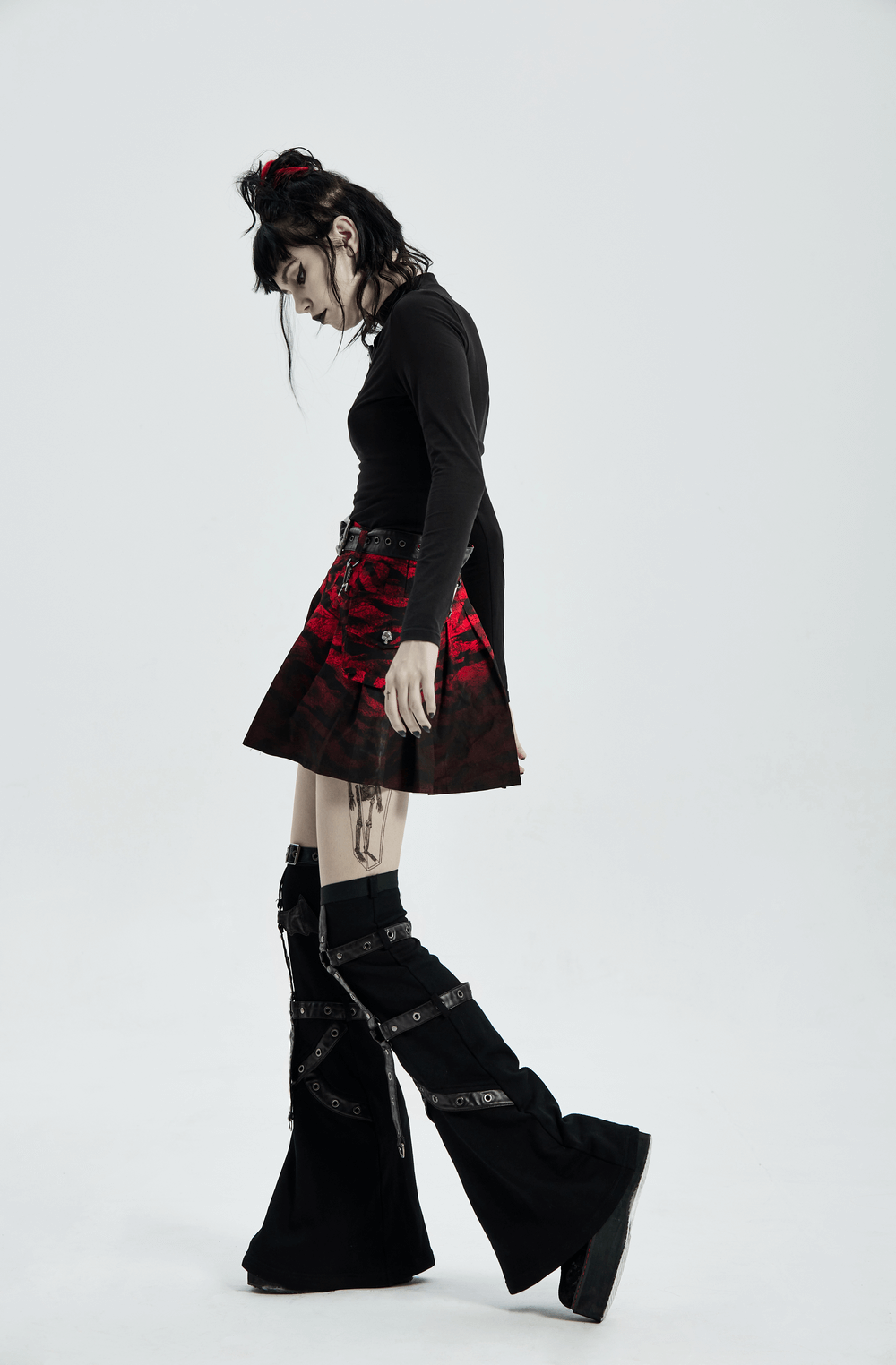 Model wearing a red print punk A-line hem skirt with removable waist bag, paired with stylish black platform boots.