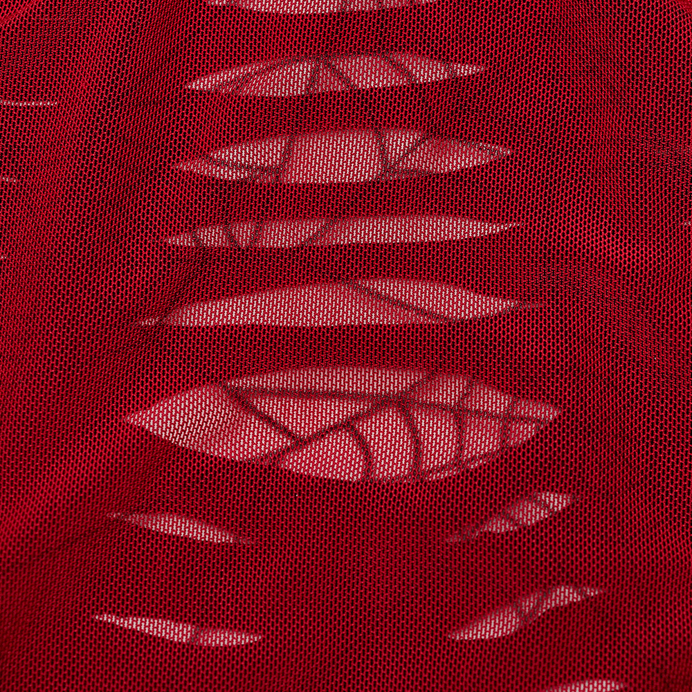 Close-up of red mesh fabric with hollowed spider web design, showcasing bold and daring style.