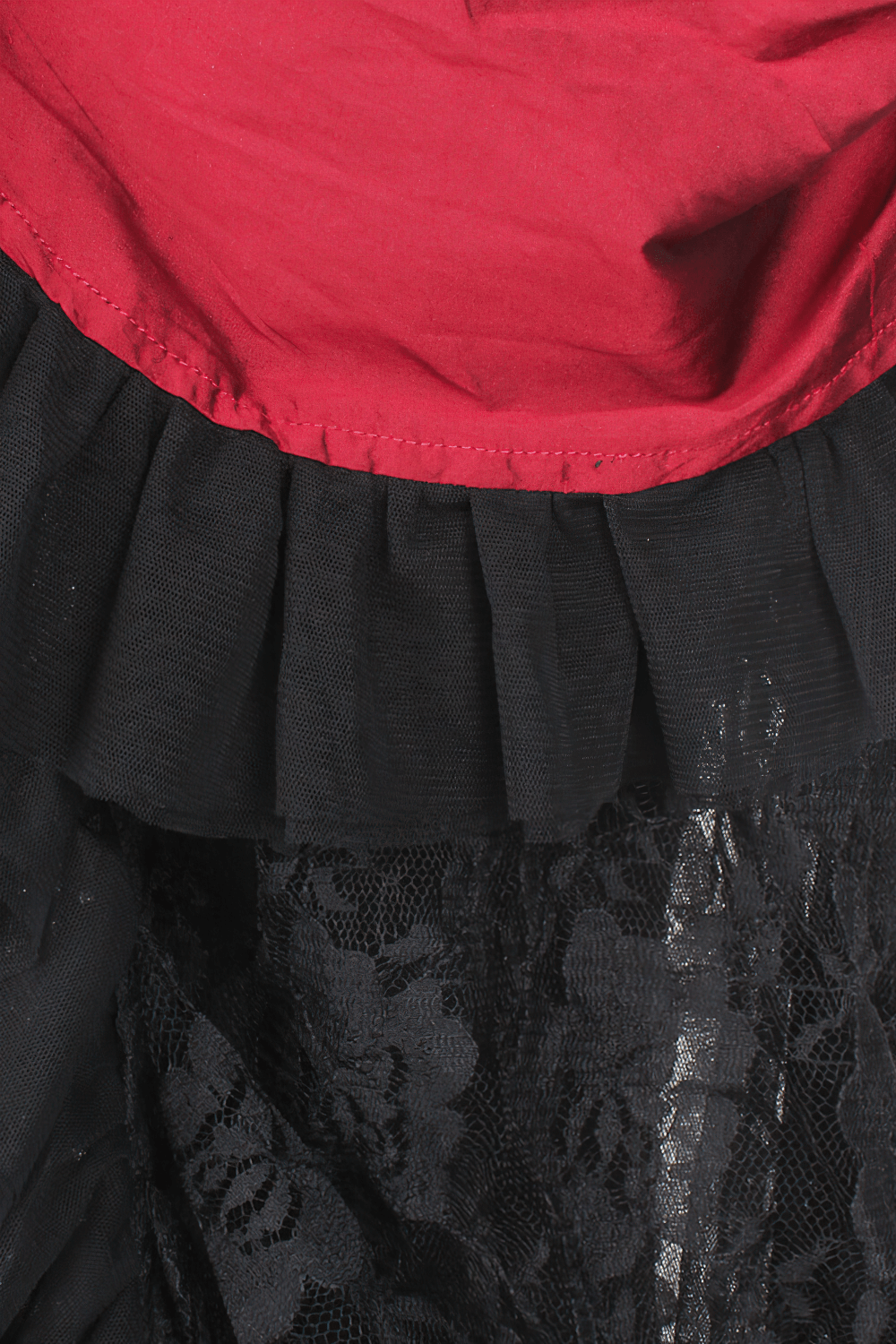 Close-up of the layered red Victorian bustle skirt with black lace and taffeta detailing.