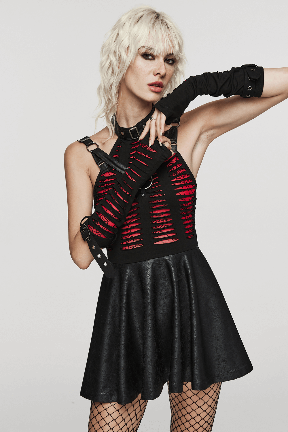 Bold goth fashion featuring red-weave gloves with buckle cuffs and a stylish black skirt.