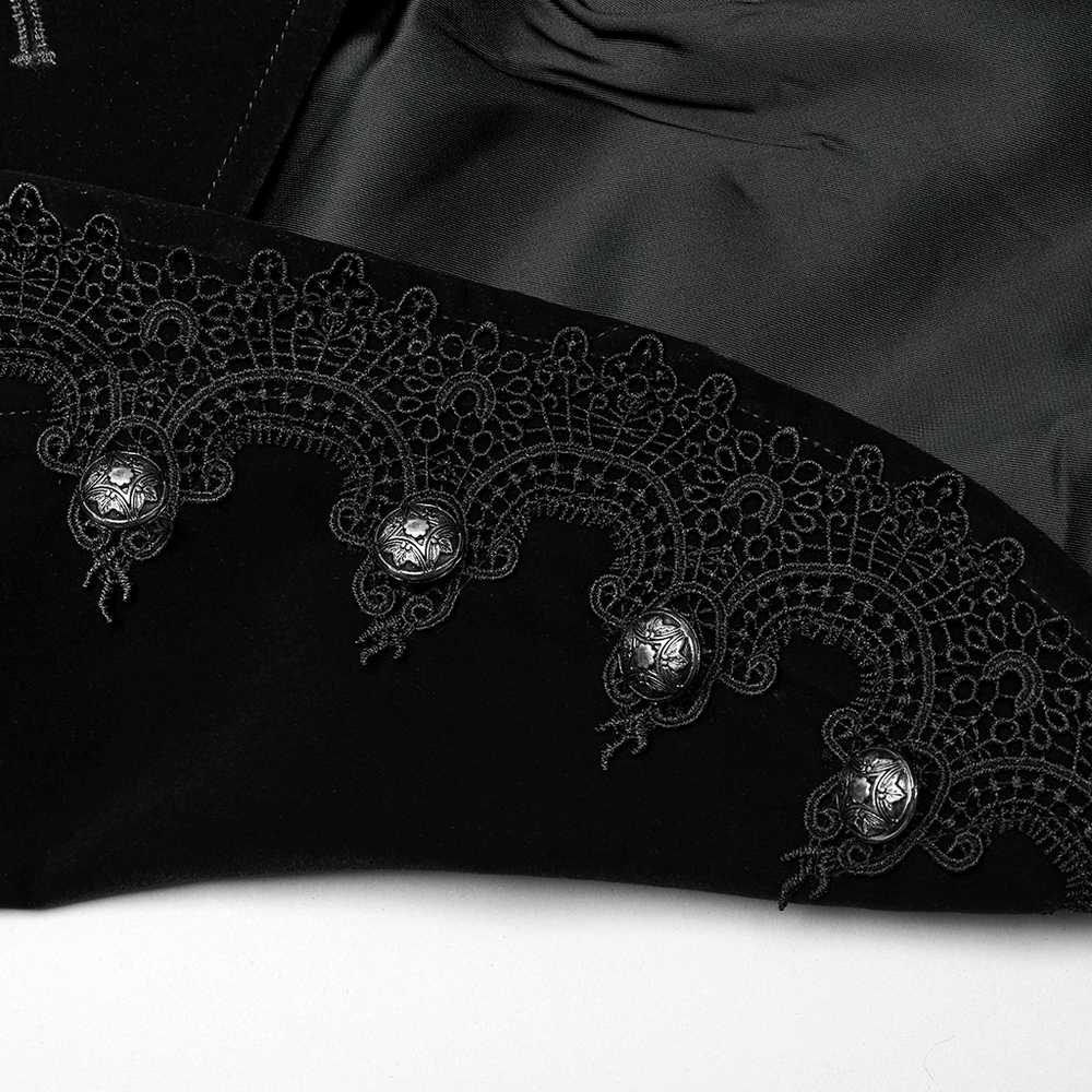 Close-up of intricate lace and engraved buttons on a refined black velvet jacket, showcasing gothic elegance.