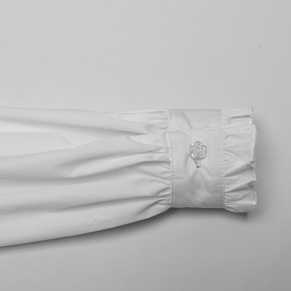 Detail of the wide ruffled cuff on a retro gothic white shirt featuring a hand-sewn rose button.