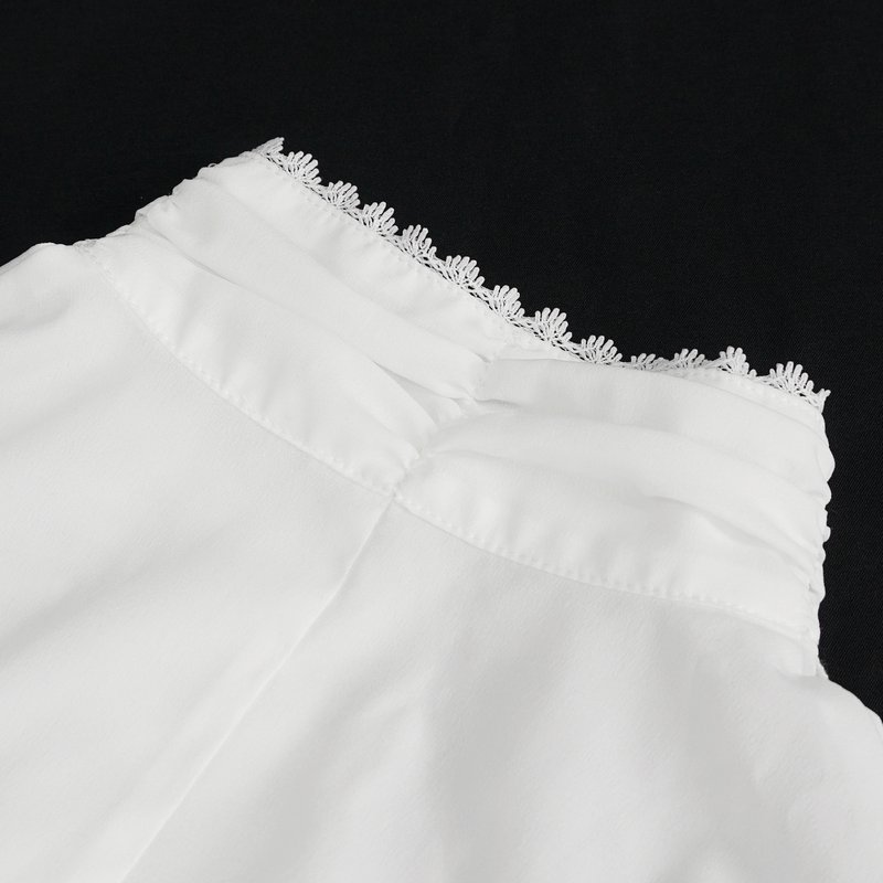 Close-up of the ruffled neckline of a Victorian Gothic inspired white blouse.