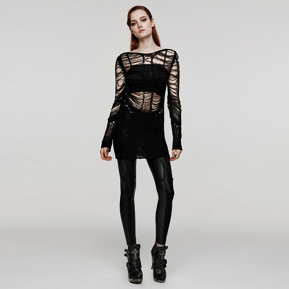 Model wearing a ripped black gothic punk long sleeve sweater with edgy hollow design and shiny black leggings.