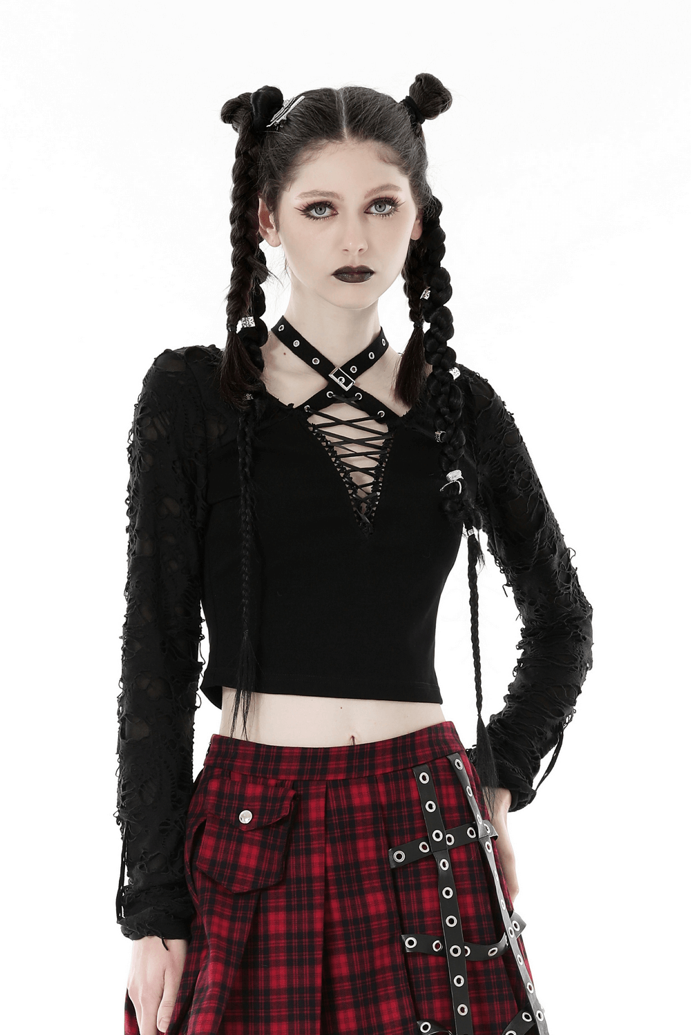 Edgy black cropped top with ripped long sleeves and statement lace-up detail, worn with a plaid skirt.