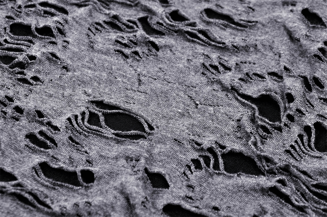 Close-up of edgy ripped mesh fabric showcasing unique holes and distressed design, perfect for a punk-inspired look.