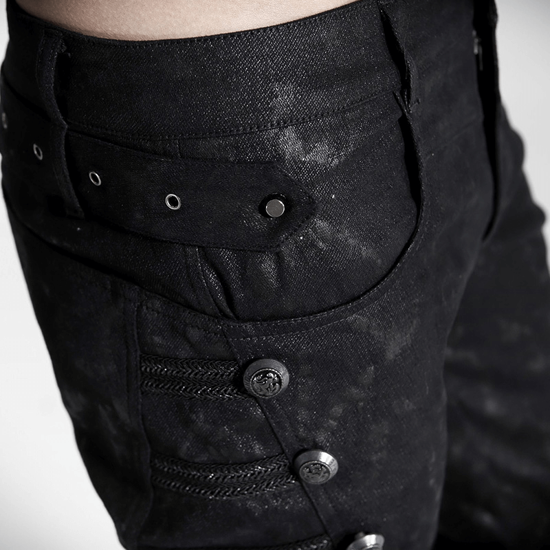 Close-up of black punk rock jeans showcasing rivet side detailing and stylish buttons.