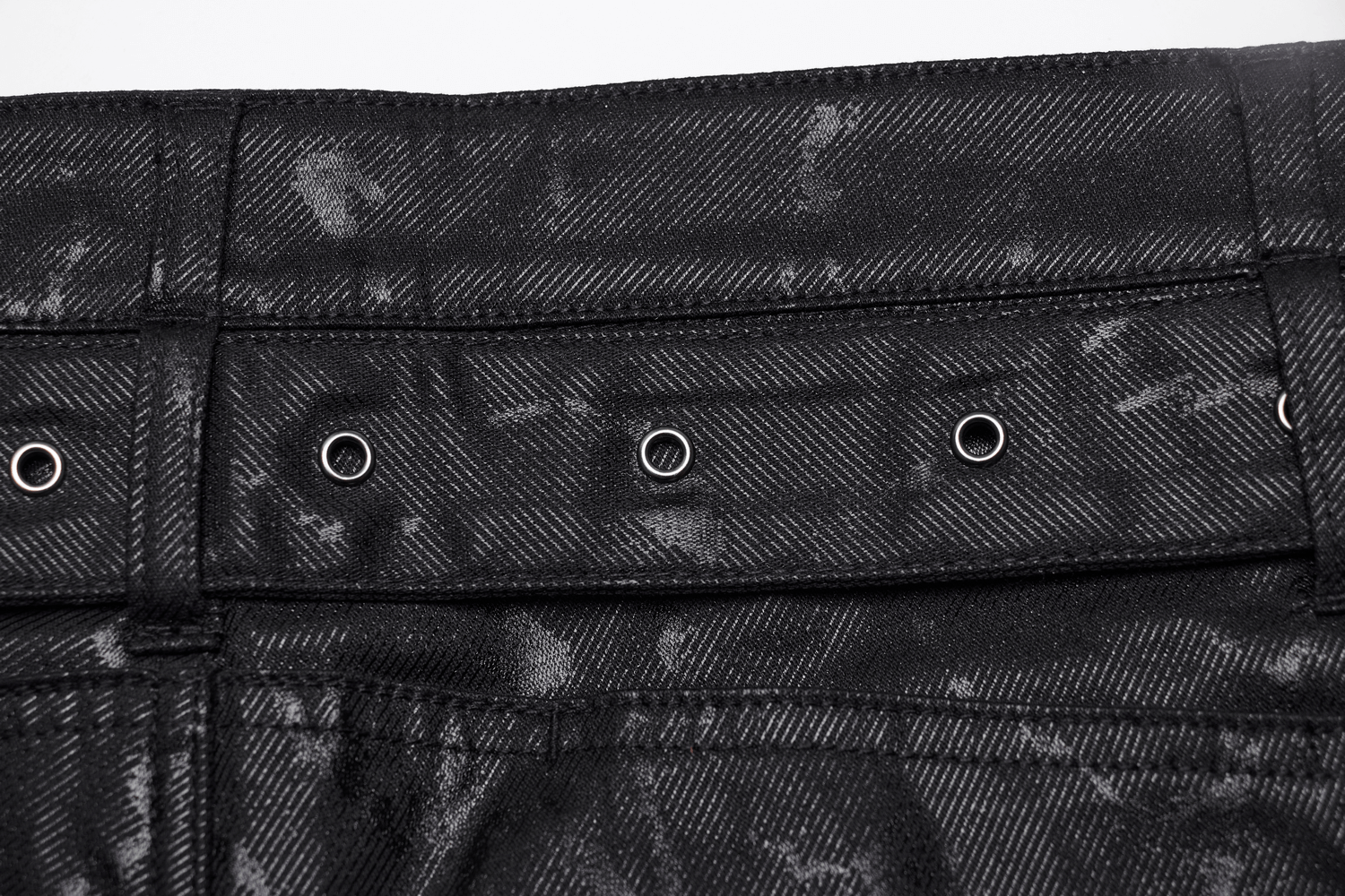 Close-up of studded rivet detailing on black punk rock jeans for men, showcasing edgy fashion and durability.