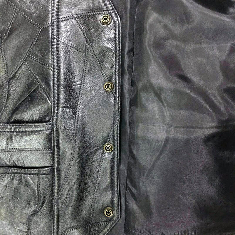 Close-up of black leather vest interior showcasing snap buttons and quilted texture, perfect for rock style outfits.