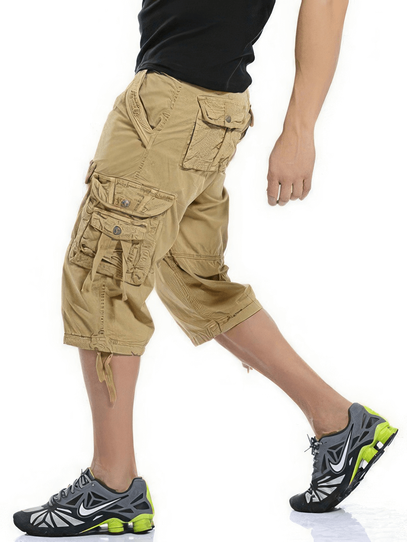 Man wearing loose camouflage cargo shorts, showcasing military style and practicality with pockets and zippers.