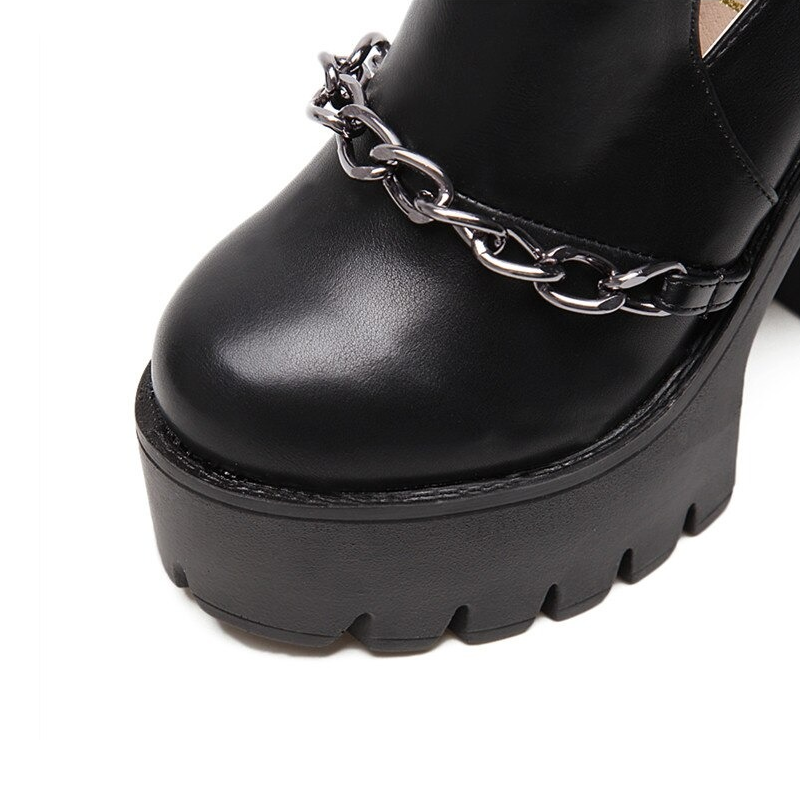 Close-up of black high heel boots with thick platform and chain detail, perfect for stylish rock outfits.