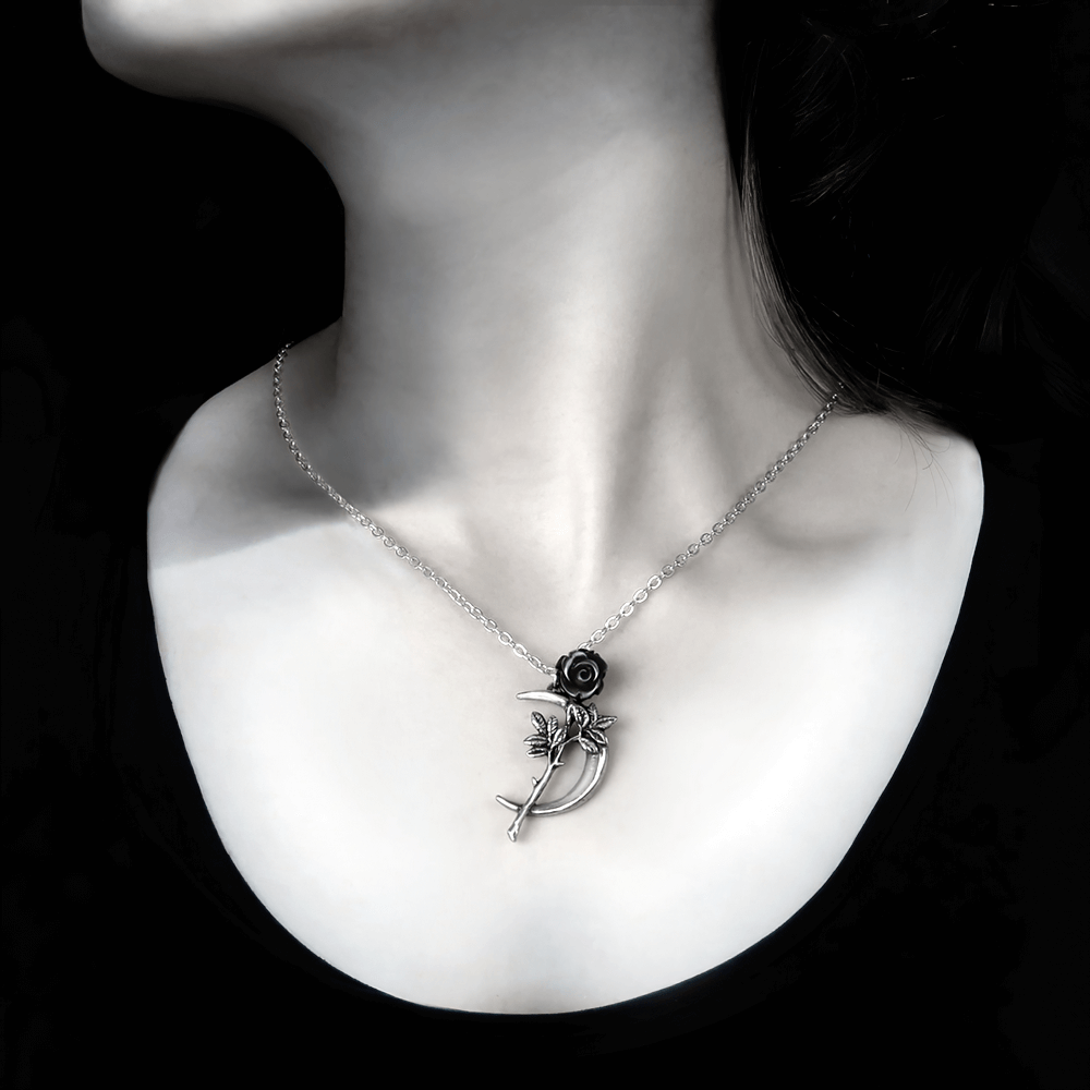 Romance pendant featuring a black rose and crescent moon, elegantly displayed on a model's neckline.