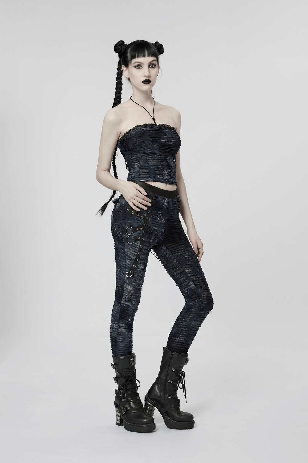 Model showcasing a chic ruched gothic bustier with lace and rivet details, paired with edgy leggings and bold boots.